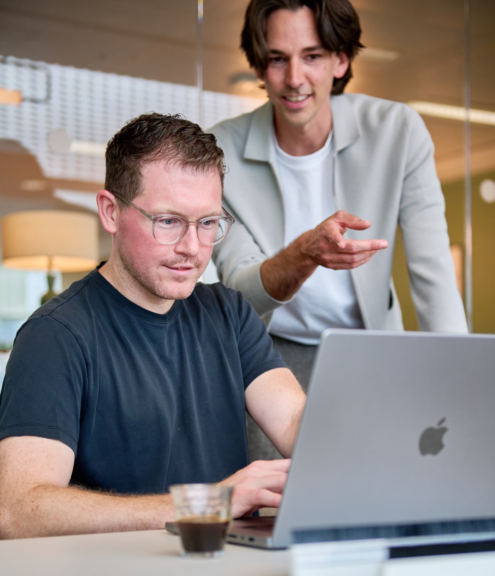 Two colleagues working through something together at a laptop