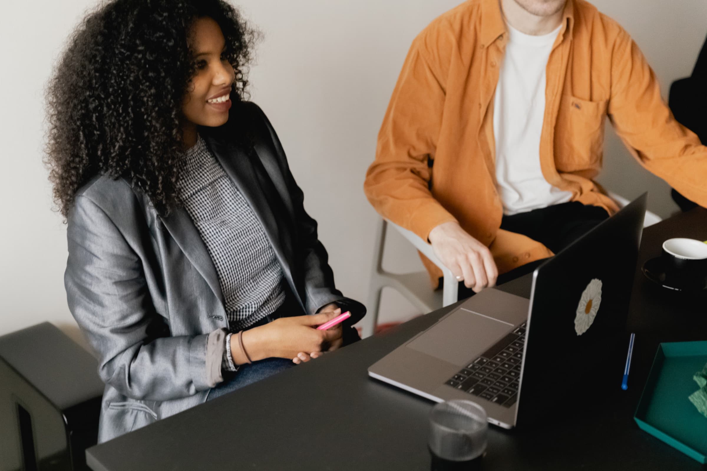 Two people reviewing work at a laptop